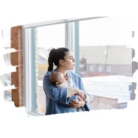 Mum holding a baby gazing out of a window