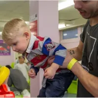 a young boy being carried by an adult