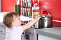 Child reaching for a hot pan on a stove