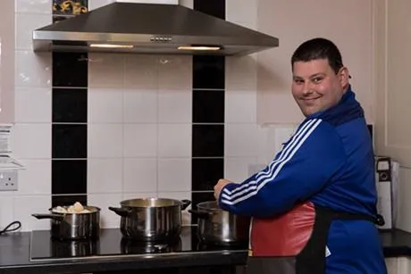 Young adult cooking living independently