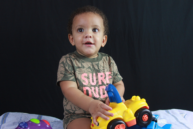 Toddler sat down with a yellow car toy